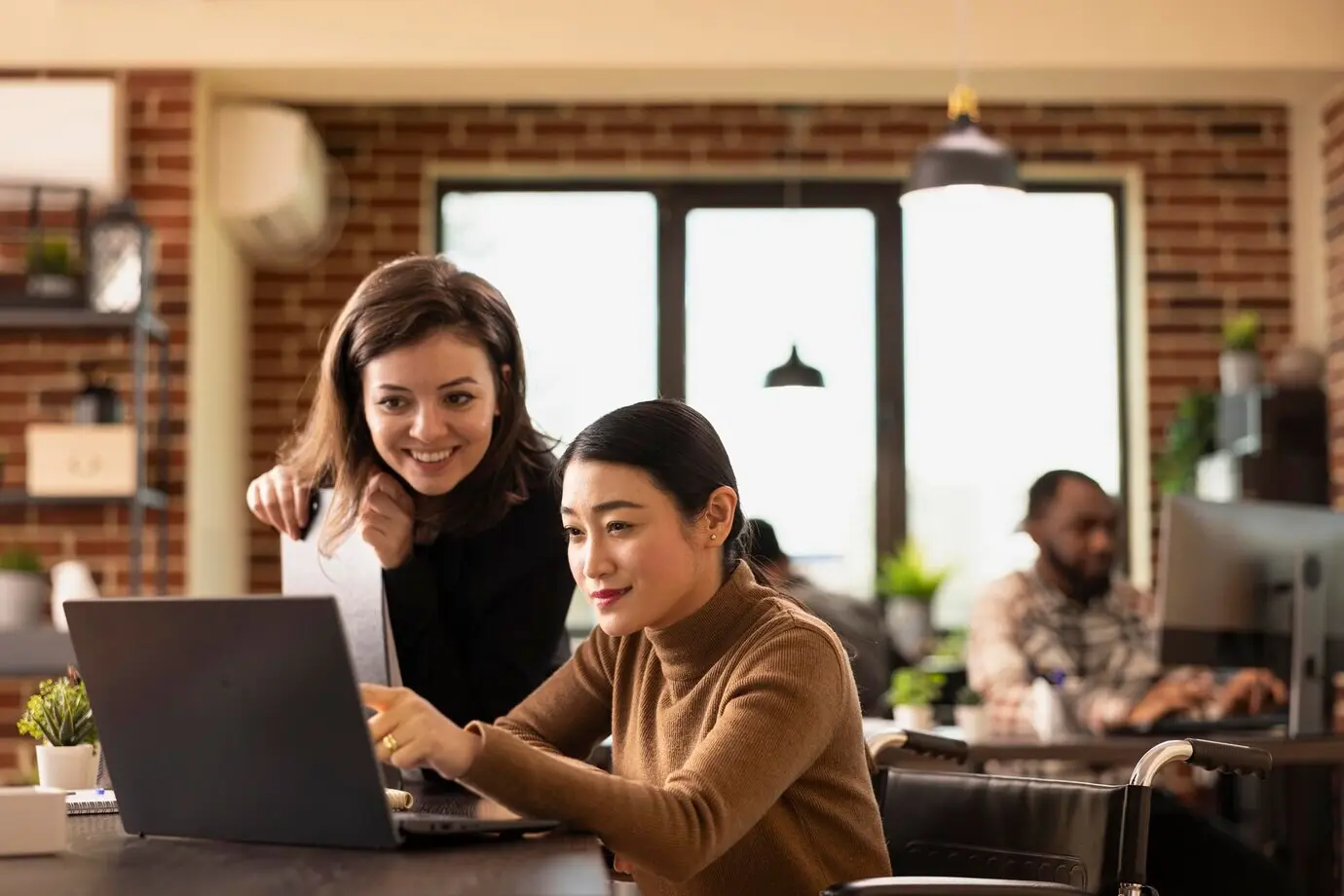 Инклюзивная рабочая среда с человеком, использующим инвалидную коляску.